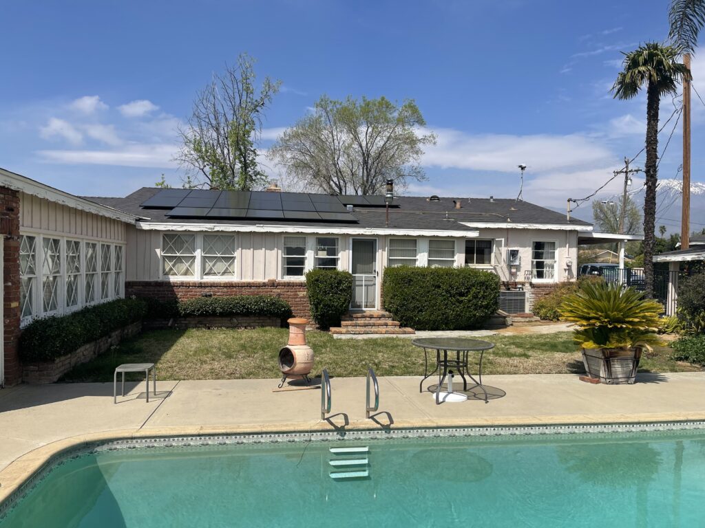 Rooftop solar panels on a Yucaipa home with a backyard pool